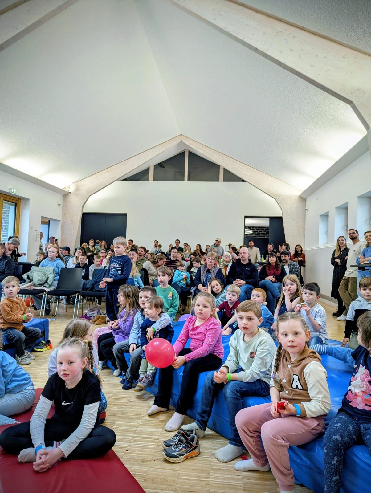 Kinder und Erwachsene sitzen beim Kinderkonzert mit Dän im Publikum
